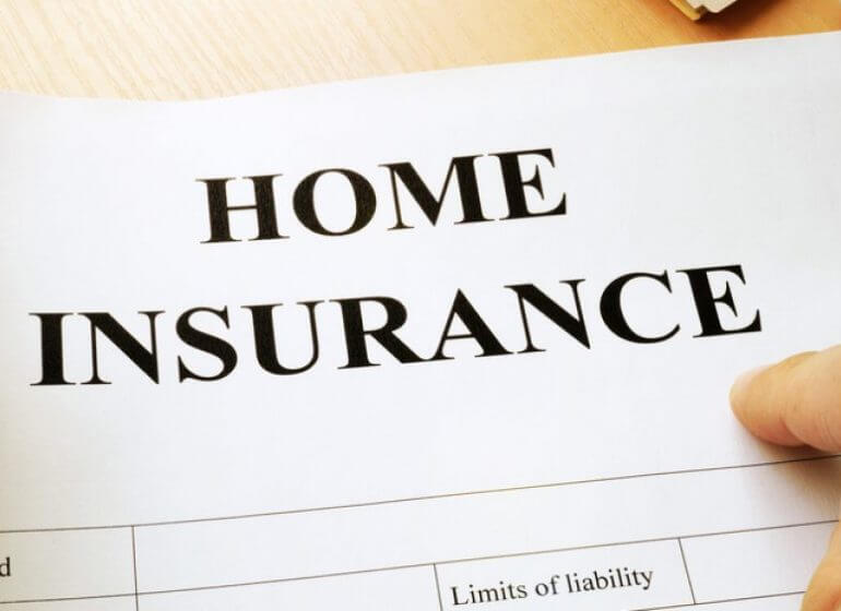 A person holding a home insurance document to save on their roof.