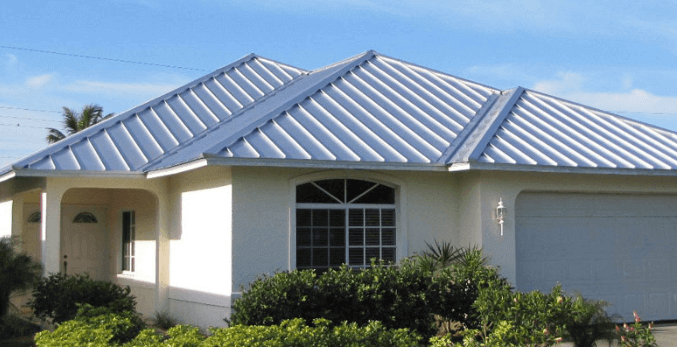 A house with a striking blue metal roof offers both aesthetic appeal and the numerous benefits of metal roofing.