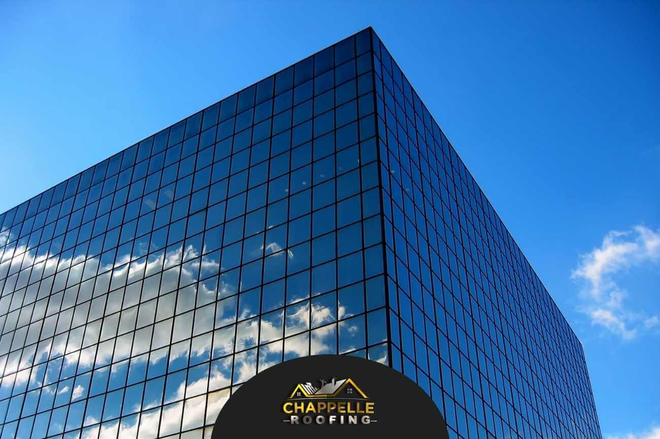 A building with a blue sky and clouds in the background, perfect for Commercial Roofing.