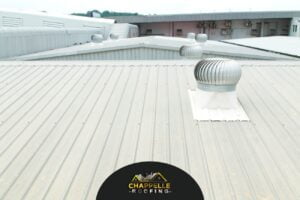 A metal roof with a fan on it, commonly seen in commercial roofing.