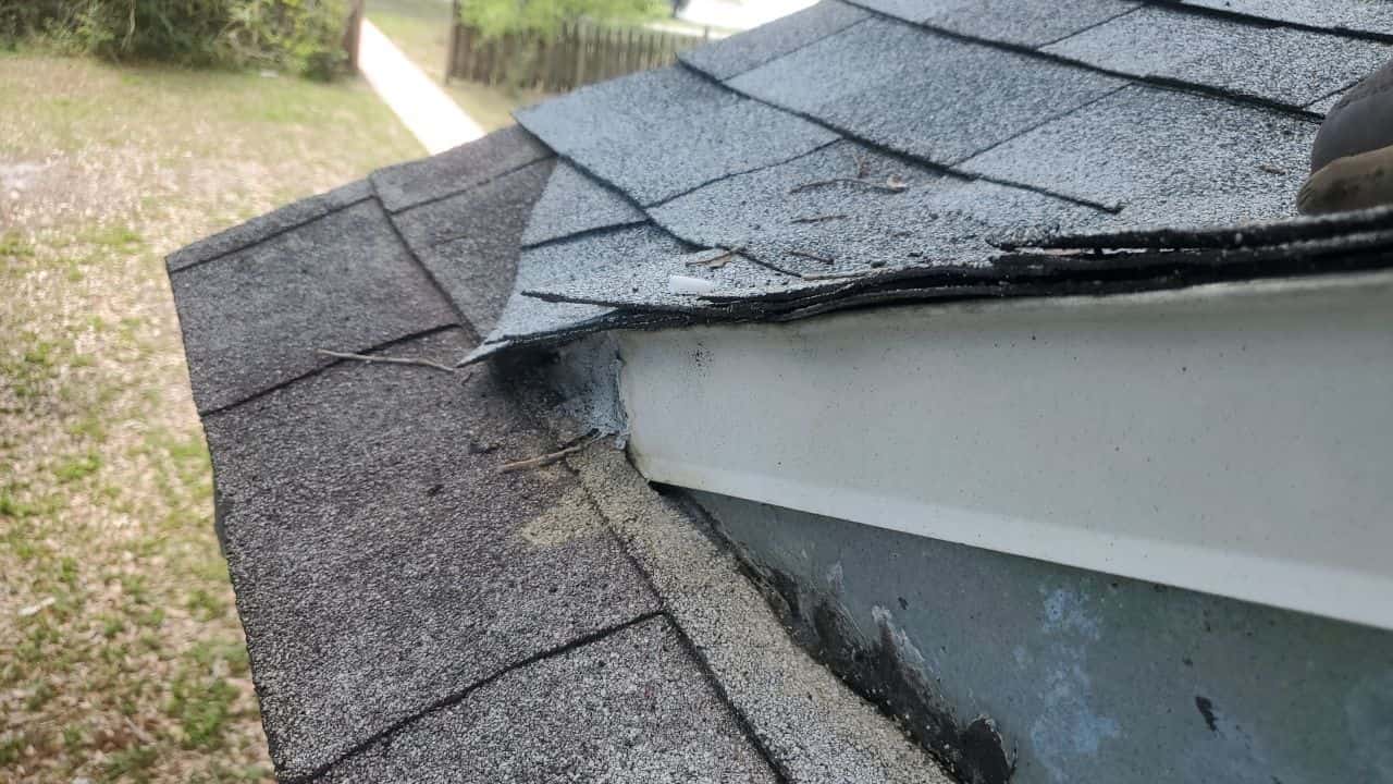 A shingled roof in need of repair.