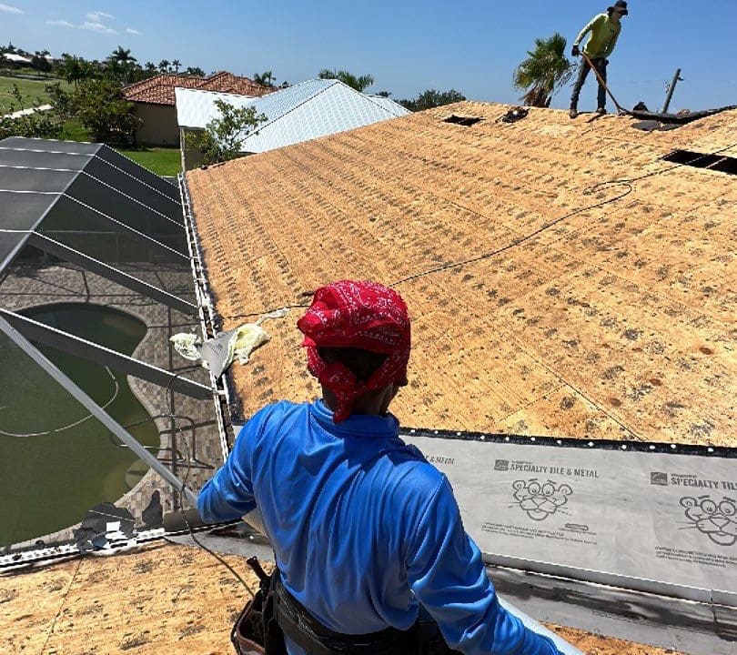 A man is performing a roof replacement on a house.