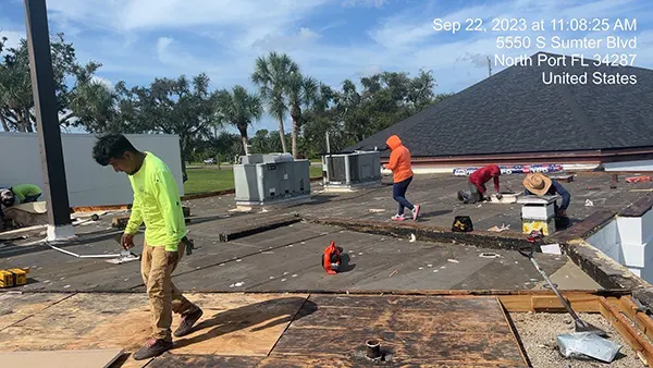 A group of individuals work on a roof.